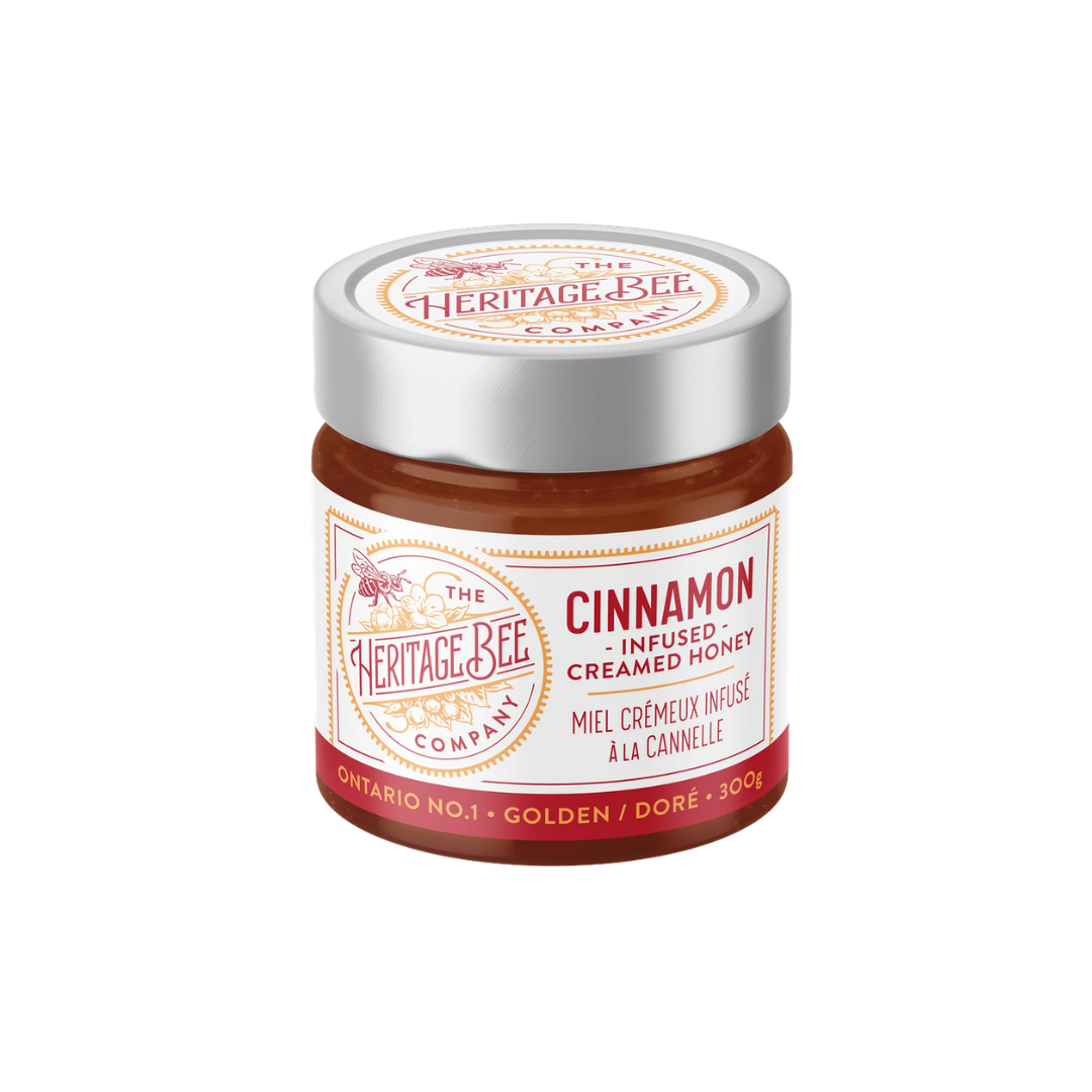 Jar of cinnamon-infused creamed honey from The Heritage Bee Company on a white background