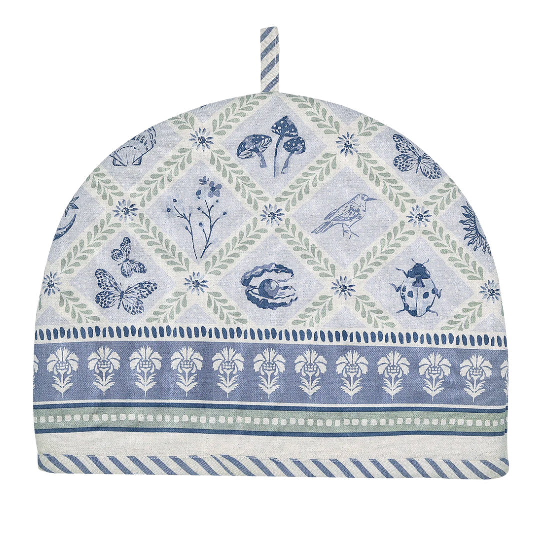 Decorative tea cozy with nature-themed pattern on a white background