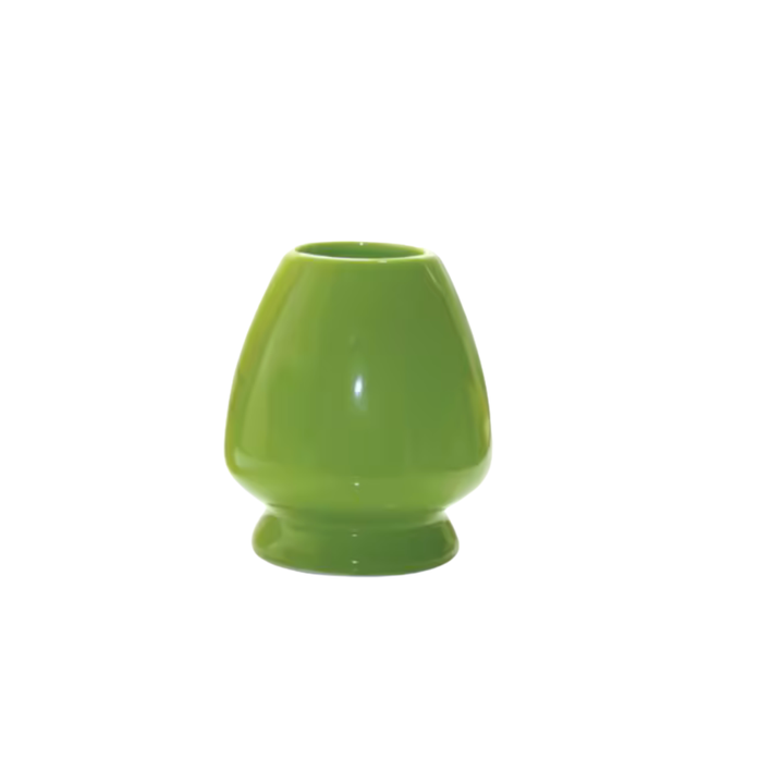 Green ceramic matcha wisk holder on a white background